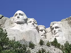 Mount Rushmore National Memorial is located in the Black Hills of South Dakota. It was sculpted by Gutzon Borglum and his son, Lincoln Borglum. The rock carving depicts the faces of four U.S. Presidents, from left to right: George Washington (1732-1799); Thomas Jefferson (1743-1826); Theodore Roosevelt (1858-1919); and Abraham Lincoln (1809-1865).