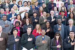 Group of people with hands over hearts singing the Pledge of Allegiance